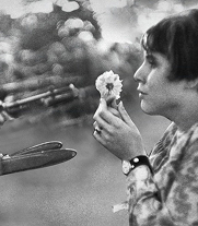 femme portant une fleur devant des fusils