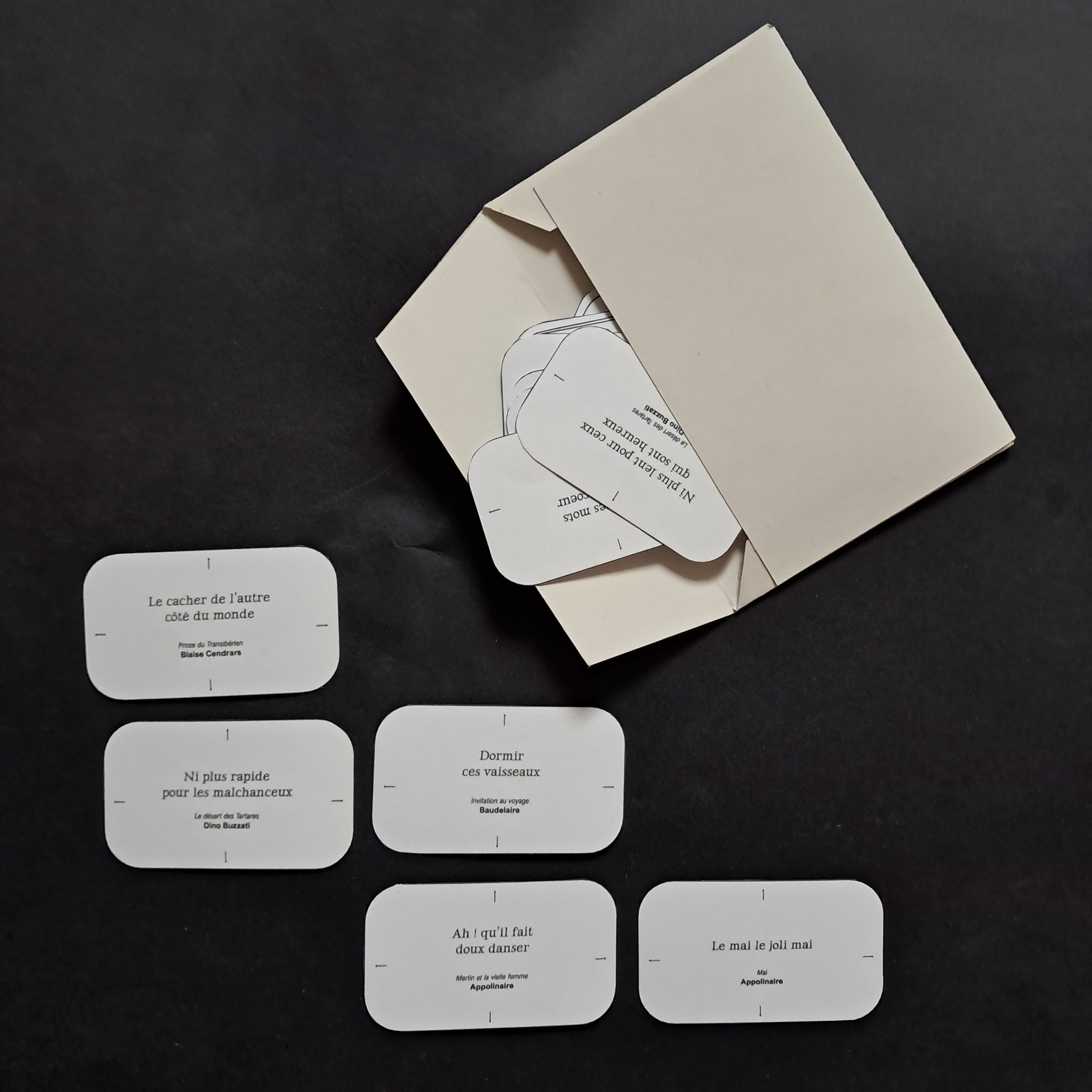 enveloppe avec des cartes de jeux avec des citations d'auteurs